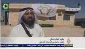 Screenshot van Al-Jazeera-interview met Al-Tabtabae met Liwa Al-Tawhid vlag op de achtergrond.